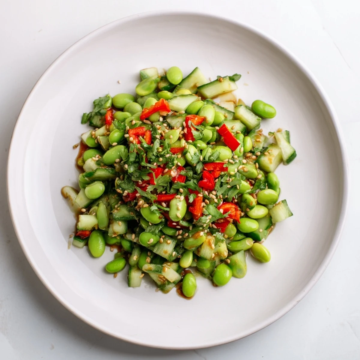 Vibrant Edamame Salad with crisp cucumber brightened by a sesame ginger dressing; ready to eat.
