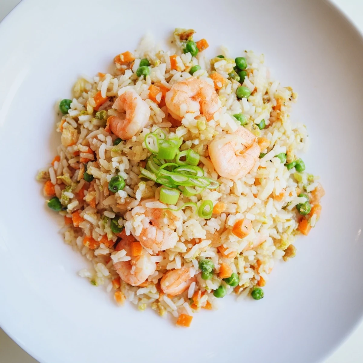 Golden-brown Shrimp Garlic Fried Rice studded with pink shrimp, green peas, and fresh spring onions, ready to serve.
