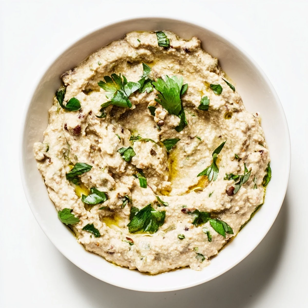 Vegan spicy black bean dip garnished with red onion and a sprinkle of smoked paprika.