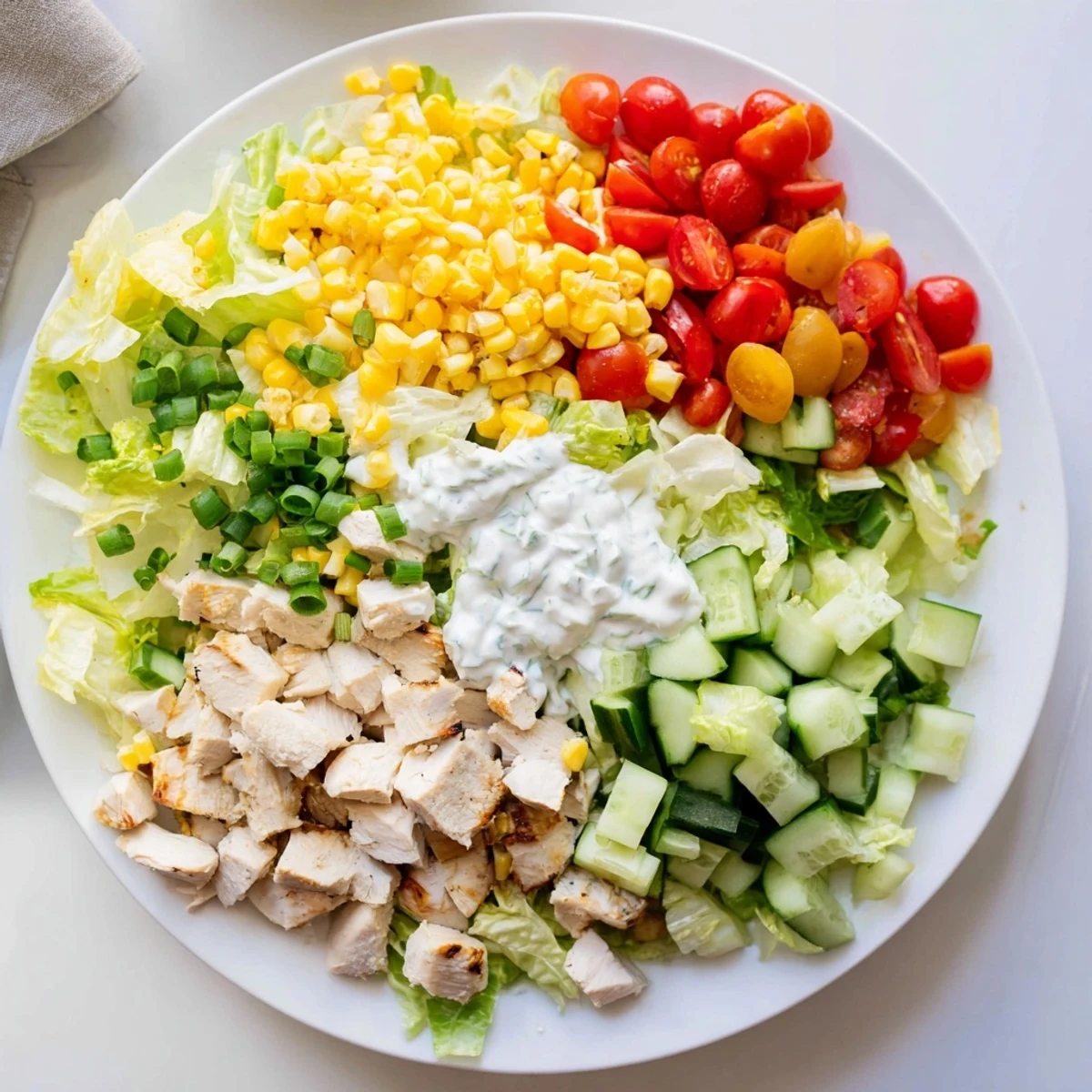 Ranch Chicken Chopped Salad tossed in creamy Greek yogurt dressing, with corn kernels and shredded cheddar glistening in natural light.