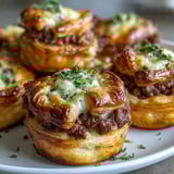 Bite-sized Mini Beef Tourtières arranged on a rustic platter, perfect for festive appetizer parties.