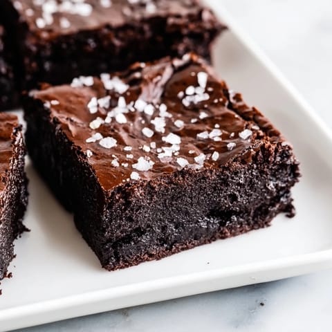 A square of decadent homemade dark chocolate and sea salt brownie, ready to enjoy after baking.