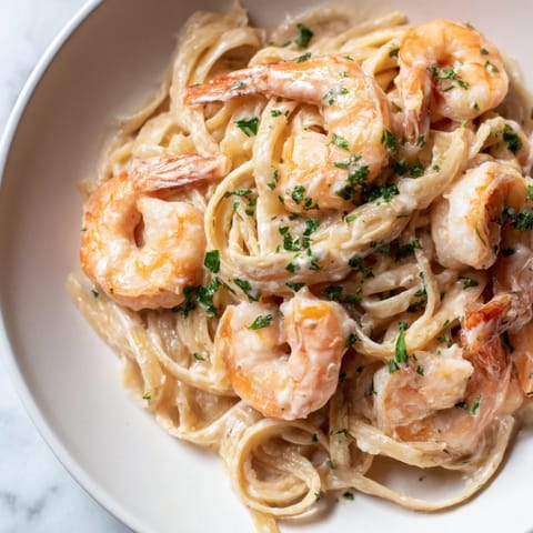 This Creamy Garlic Shrimp Pasta is served hot with lemon wedges, ready for an elegant weeknight dinner.  