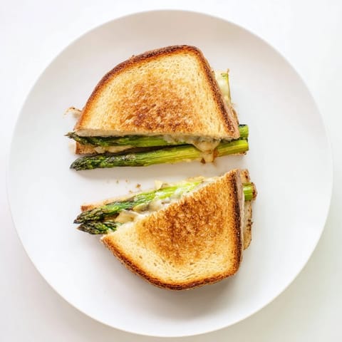 Enjoy the Asparagus & Brie Grilled Cheese, featuring buttery toast with gooey cheese and tender spears, ideal with a crisp side salad.