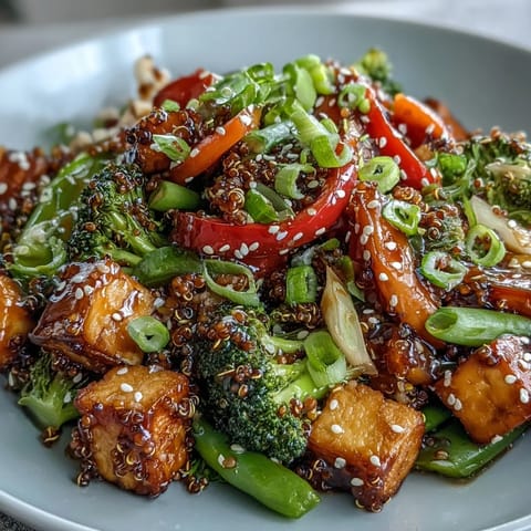 Fluffy quinoa topped with crisp stir-fried vegetables and crispy tofu, all drizzled with a glossy homemade teriyaki sauce.