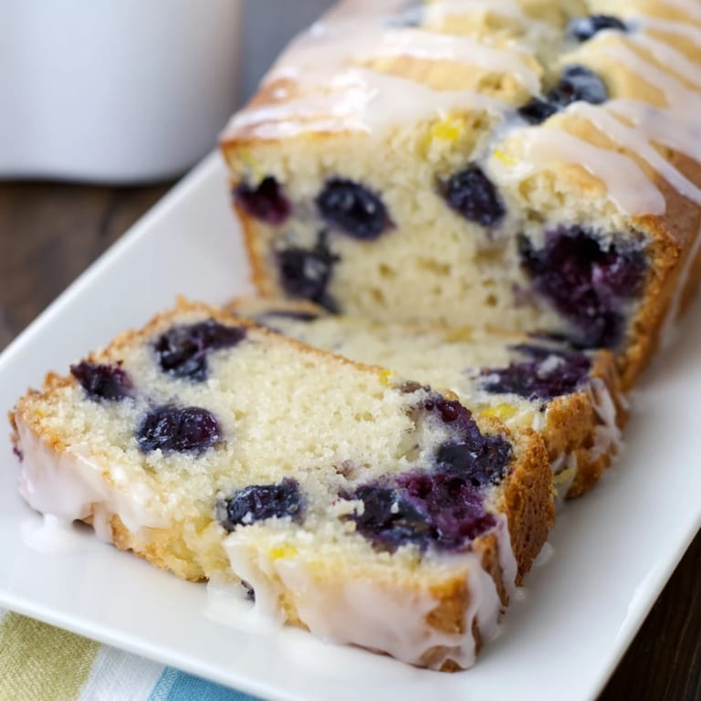 Close-up of a delightful slice of Lemon Blueberry Yogurt Loaf, moist and vibrant on a plate.