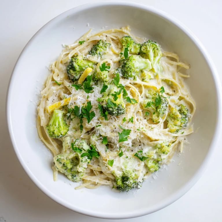 Hearty One-Pot Lemon Broccoli Pasta twirls on a fork, garnished with fresh parsley and grated Parmesan for a zesty spring dinner.  