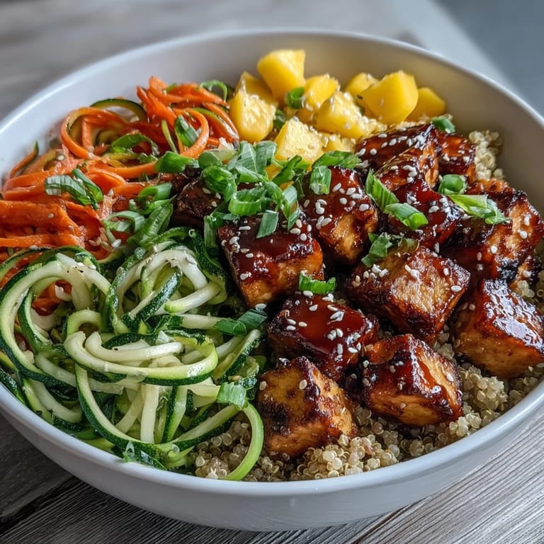 Ready-to-eat Easy Teriyaki Quinoa Bowl featuring crispy tofu, fluffy quinoa, colorful spiralized veggies, and fresh mango slices.
