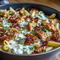 One-pot French onion chicken pasta with caramelized onions and melty Gruyère cheese in a creamy broth.  