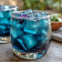 Vibrant blue butterfly pea flower lemonade transforms to purple with fresh lemon juice in this magical color-changing drink.